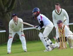 People playing cricket to encourage cricketer
