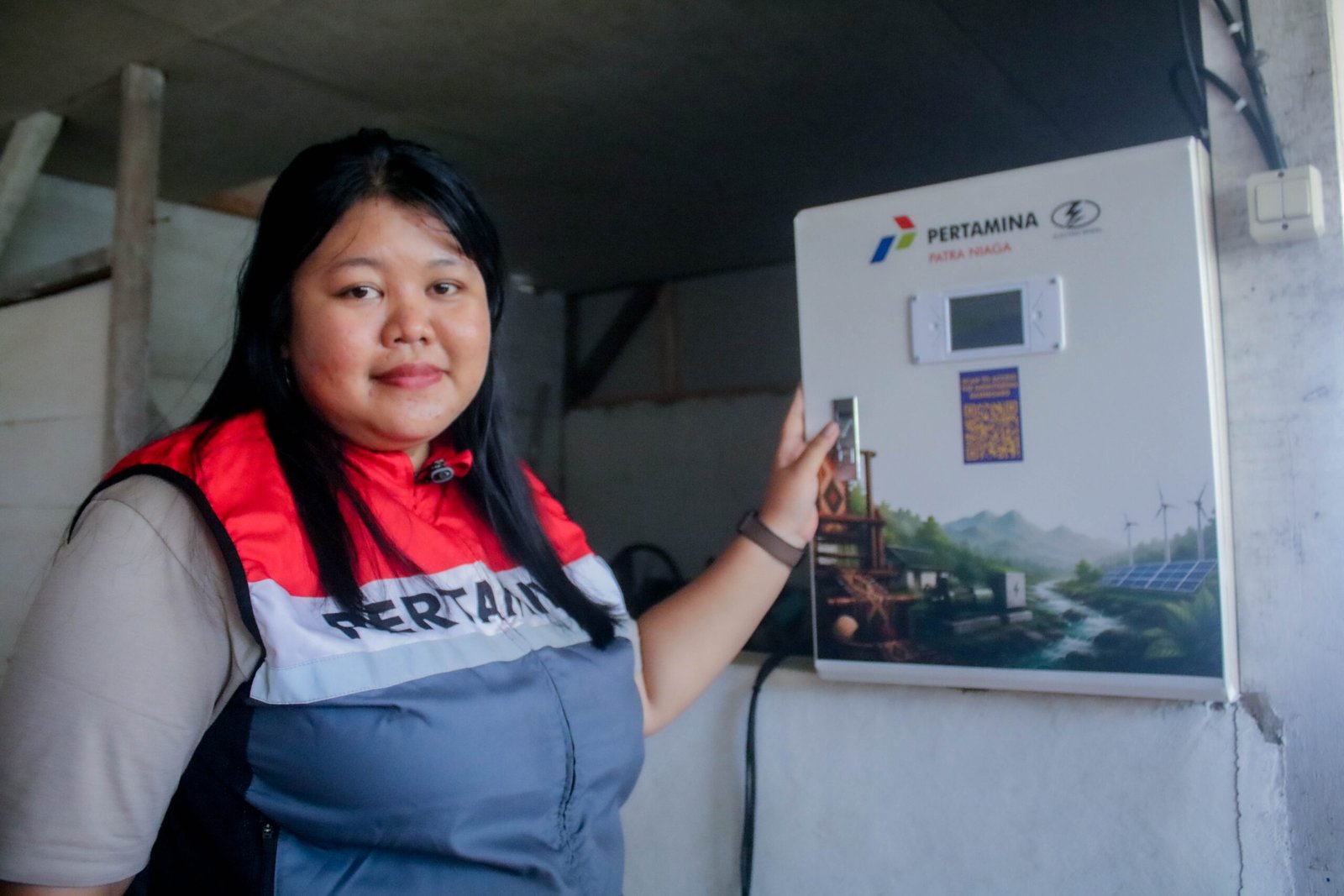 Community Development Officer PT Pertamina AFT BIL, Erly Yeniska Hermitasari sedang menunjukkan salah satu perangkat sistem energi terbarukan yang dilengkapi panel surya dan teknologi pembangkit listrik. Perangkat tersebut menjadi bagian dari pemanfaatan energi bersih untuk mendukung kebutuhan listrik masyarakat